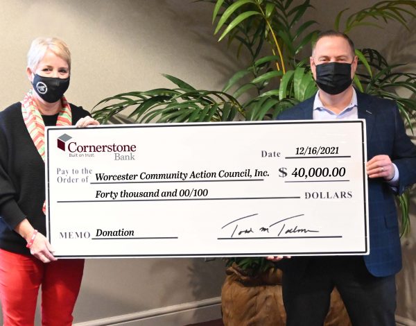 A man and woman hold a large donation check for $40,000 from Cornerstone Bank to Worcester Community Action Council.