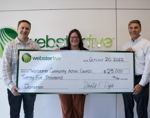 Three people smiling and holding a large ceremonial check for $25,000 to Worcester Community Action Council from Webster Five.